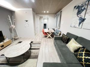 a living room with a couch and a table at Sky Terrace Kawaguchi in Kawaguchi