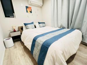 a bedroom with a bed with a blue and white blanket at Sky Terrace Kawaguchi in Kawaguchi
