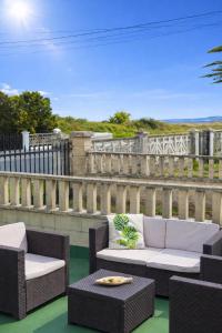 a patio with two chairs and a couch and a table at Villa Las Catedrales - Piscina Privada - Frente a la playa - Amplio jardín in Barreiros