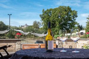 a bottle of wine sitting on a table with two wine glasses at Tuscia Holidays in Zepponami