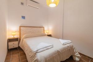 a bedroom with a bed with towels on it at El Carmen - Villa Rural con Piscina Privada y Patio Andaluz in Ugíjar +15 photos