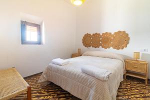 a bedroom with a bed with two towels on it at El Carmen - Villa Rural con Piscina Privada y Patio Andaluz in Ugíjar