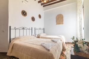 two beds in a bedroom with white walls at El Carmen - Villa Rural con Piscina Privada y Patio Andaluz in Ugíjar