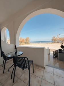 a table and chairs in a room with a view of the beach at Aegean Nest Beach Studios - Adults only in Monolithos