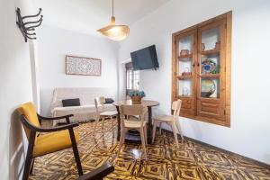 a living room with a table and chairs and a couch at El Carmen - Villa Rural con Piscina Privada y Patio Andaluz in Ugíjar