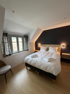 a bedroom with a large white bed in a room at Le Refuge des Clavendiers in Nuits-Saint-Georges
