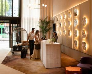 a group of people standing at a counter in a lobby at Mercure Melbourne La Trobe Street in Melbourne