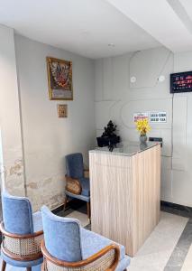 a waiting room with blue chairs and a counter at Hotel Classic in Pānīpat