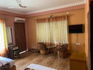 a room with a bed and a table and chairs at Hotel The Mint Garden in Pokhara
