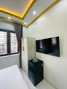 a bedroom with a bed and a small refrigerator at Hotel 24h in Hai Phong