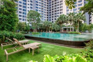 a park with a pool with a bench and chairs at Cavera Bukit Bintang in Kuala Lumpur