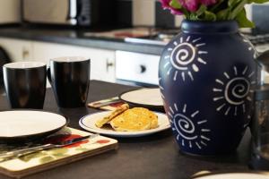 a table with plates of food and a vase at Ysgubor Tawe in Pontardawe