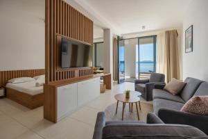 a living room with a couch and a tv at Wind Rose Maestral-beachfront in Igrane