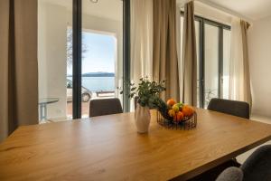 a dining room table with a bowl of fruit on it at Wind Rose Maestral-beachfront in Igrane