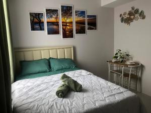 a bed in a bedroom with pictures on the wall at Clover88 Studio Room is in the City but with a seaview in Mandaue City