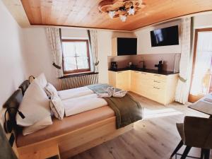 a bedroom with a large bed and a tv at Schlosserhof in Telfes im Stubai