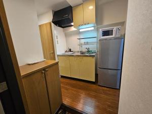 a small kitchen with a refrigerator and a microwave at Namba Ebisu Tower701 in Osaka
