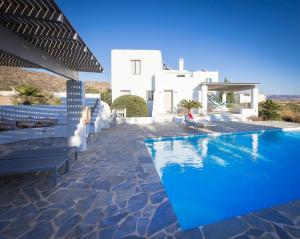 a swimming pool in front of a white villa at Villa Ione in Mikri Vigla