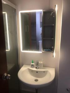 a bathroom with a white sink and a mirror at Clover88 Studio Room is in the City but with a seaview in Mandaue City +9 photos