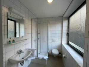 a white bathroom with a sink and a toilet at Klosterhof Neustadt am Main in Neustadt am Main +51 photos