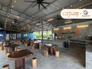 a restaurant with wooden stools in a large room at The Coco Journey - Eco Tent in Kelebang Besar