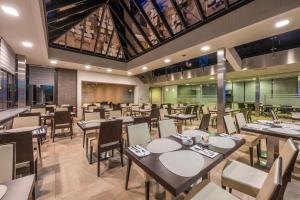a restaurant with tables and chairs in a room at Hotel Falko in Meise
