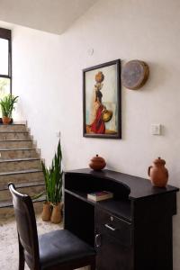 a desk in a room with a painting on the wall at Coffee Bean Inn in Bangalore