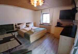 a small room with a bed and a television at Schlosserhof in Telfes im Stubai