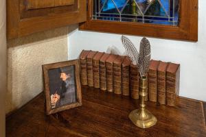 a wooden table with a vase and a picture and a book at La Maison Bakéa in Cordes-sur-Ciel