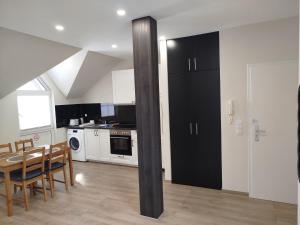 a kitchen with a table and a black refrigerator at Appartement Design 2 - Altenstadt in Altenstadt