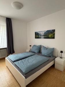 a bedroom with a large bed with blue pillows at Klosterhof Neustadt am Main in Neustadt am Main