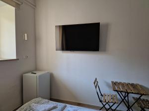 a room with a tv on the wall with a table and a chair at Ljubljana rest nest in Ljubljana