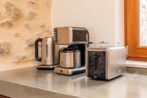 a kitchen counter with three coffees and a coffee maker at Casa Abeurador, con mucho encanto en el centro de Artà in Artá