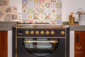 a kitchen with a black oven with a counter at Casa Abeurador, con mucho encanto en el centro de Artà in Artá