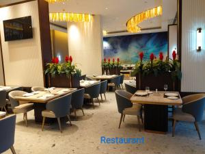 a restaurant with tables and chairs and red flowers at La Belle - The Business Hotel in Lubumbashi