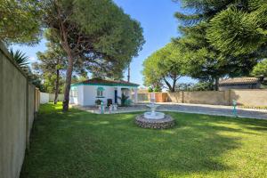 a yard with a white house and a fence at Chalet Amanecer Chiclana in Novo Sancti Petri