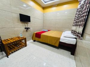 a bedroom with a bed and a tv in it at GSR RESIDENCy in Kanchipuram