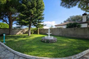 a garden with a fountain in the middle of a yard at Chalet Amanecer Chiclana in Novo Sancti Petri