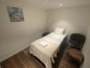 a small room with a bed and a chair at Port Hotel Ocean Villa in Karlshamn
