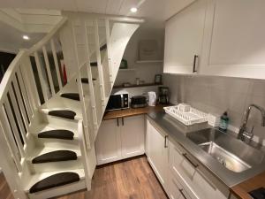 a kitchen with a spiral staircase next to a sink at Port Hotel Ocean Villa in Karlshamn