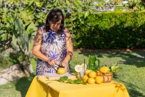 a woman is cutting oranges on a table at Hotel Al Mulino - Mediterranean Garden Retreat in AnaCapri in Anacapri