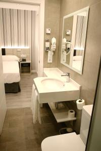 a bathroom with a sink and a toilet and a bed at Parque Florida in Ciudad-Rodrigo +18 photos