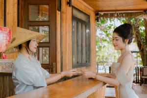 two women are standing at a table in a building at Sim Forest Resort in Phú Quốc +53 photos