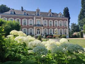 a large house with white flowers in front of it at Château de Beaucamp - Castel des anges in Wailly-Beaucamp