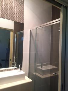 a bathroom with a sink and a glass shower at North Adelaide Studio in North Adelaide