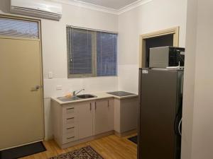 a kitchen with a sink and a refrigerator at North Adelaide Studio in North Adelaide