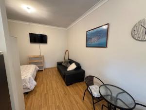 a living room with a bed and a couch at North Adelaide Studio in North Adelaide