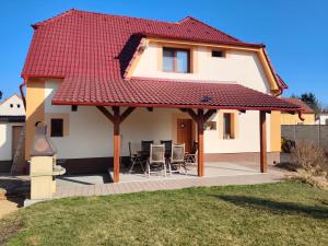 a house with a red roof and a patio at Apartmán 38 in Opolany