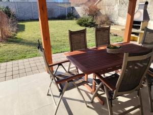 a wooden table and chairs on a patio at Apartmán 38 in Opolany