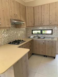 a kitchen with wooden cabinets and a sink and a stove at Villa Ti Amo Flat in Ramsgate